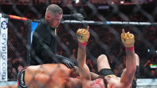 Lightweight champion Islam Makhachev (R) celebrates after submitting Dustin Poirier at UFC 302 to retain his lightweight title.